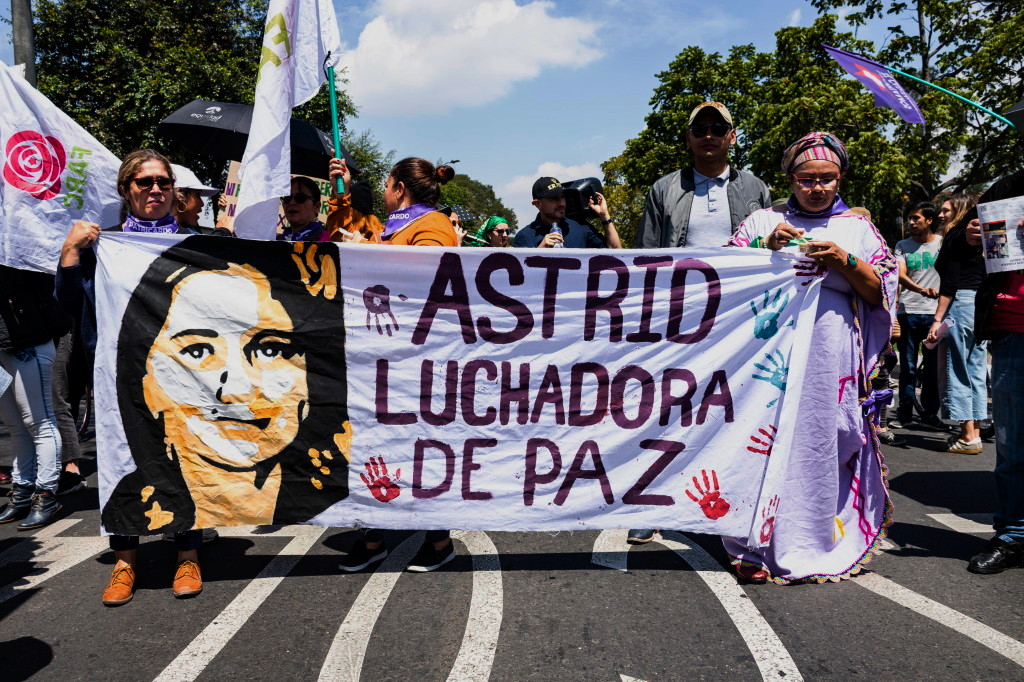 Hombres y mujeres marchando con un pancarta que dice "Astrid, luchadora de paz", en honor a Astrid Conde, excombatiente de la FARC recientemente asesinada. Foto: Leidy Benítez