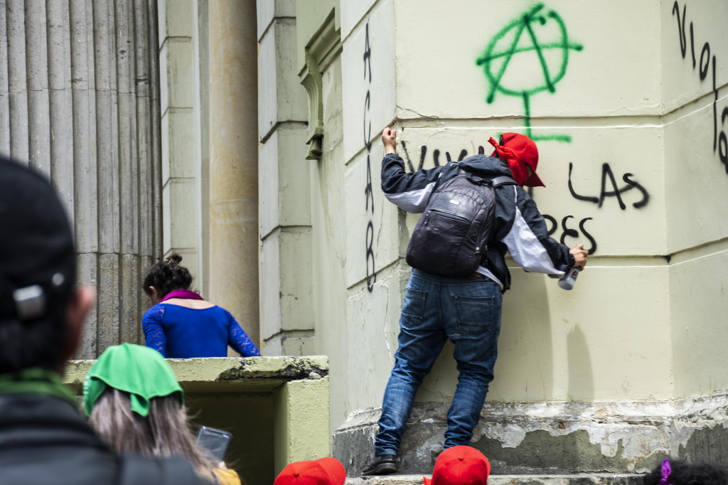 Un joven, de espaldas, pinta "Vivan las mujeres" sobre una pared de la Basílica del Voto Nacional. Foto: Leidy Benítez