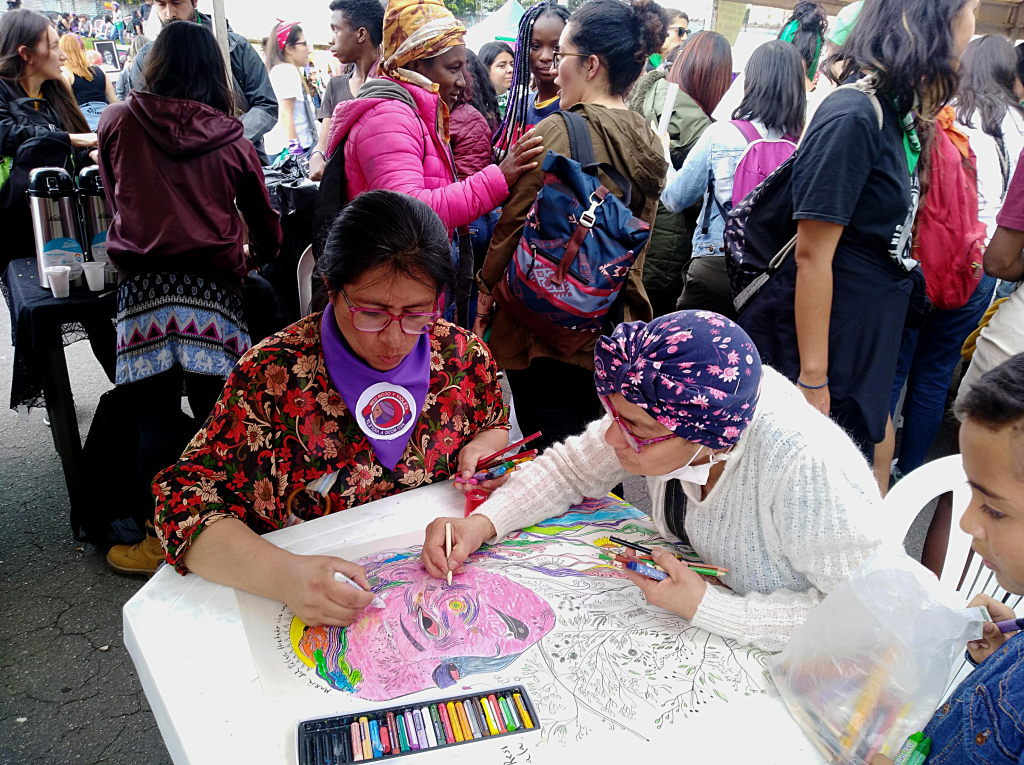 Mujeres reunidas, dos de ellas dibujan juntas. Foto: Andrea Umaña