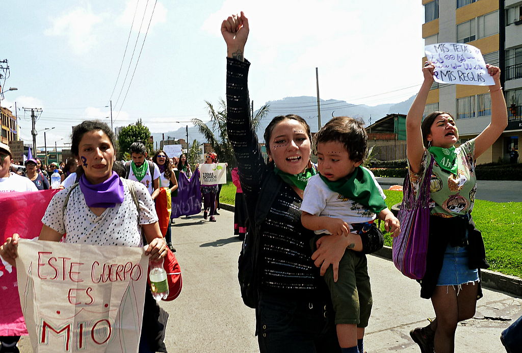 Mujeres marchando, una de ellas con un niño en brazos, otra de ellas porta un cartel que dice: "Este cuerpo es mío". Foto: Marcela Zuluaga