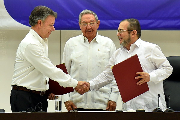 El presidente Juan Manuel Santos y Rodrigo Londoño Echeverry 'Timoleón Jiménez', máximo comandante de las FARC, firman el acuerdo sobre el fin del conflicto en La Habana. Foto: Juan David Tena (presidencia).