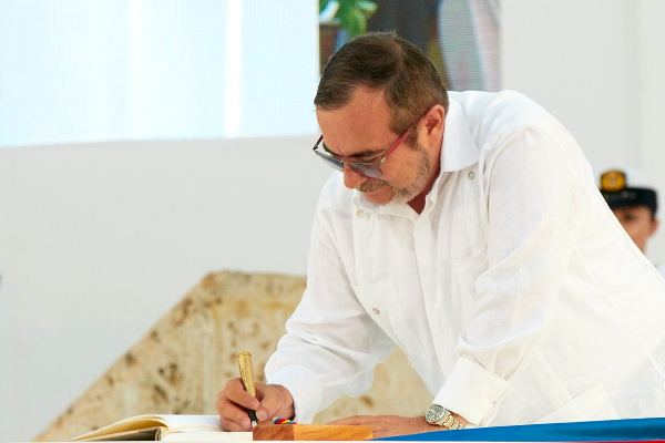 Rodrigo Londoño, jefe de las FARC-EP, firma el acuerdo final para la terminación del conflicto entre su organización y el Gobierno Nacional. Foto: Delegación de paz de las FARC.