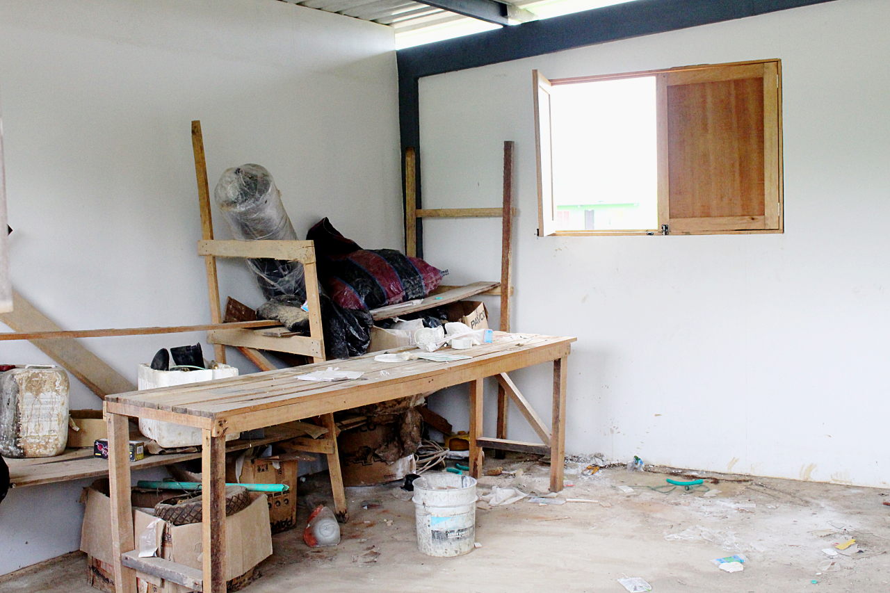 Mesas y estanterías rotas, cajas y basura por el suelo de un taller. Foto: Omar Vera.