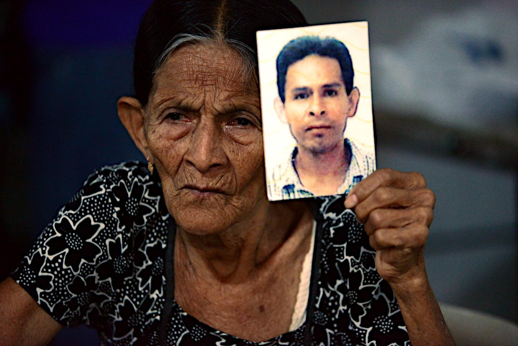 Una mujer muestra la foto de su hijo desaparecido, uno de los 43 jóvenes de Ayotzinapa. Foto: Daniel Cima, CIDH