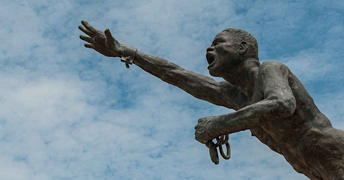 Estatua de Benkos Biohó con su mano alzada hacia el cielo