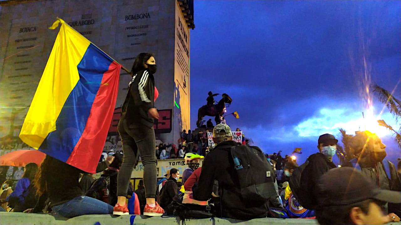 Una joven con una bandera de Colombia protesta en el Monumento a los Héroes de Bogotá. Foto: Alexandra Correa