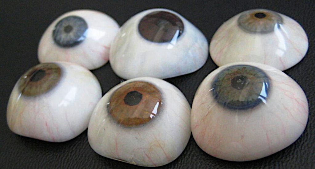 Seis prótesis oculares de distintos colores sobre un fondo negro. Foto: Germán Tenorio