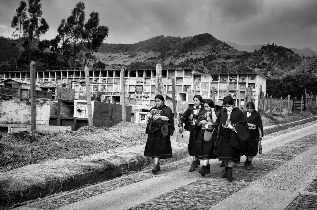 Un grupo de mujeres misak pasa frente al cementerio de Guambia. Foto: Manuel Ortiz
